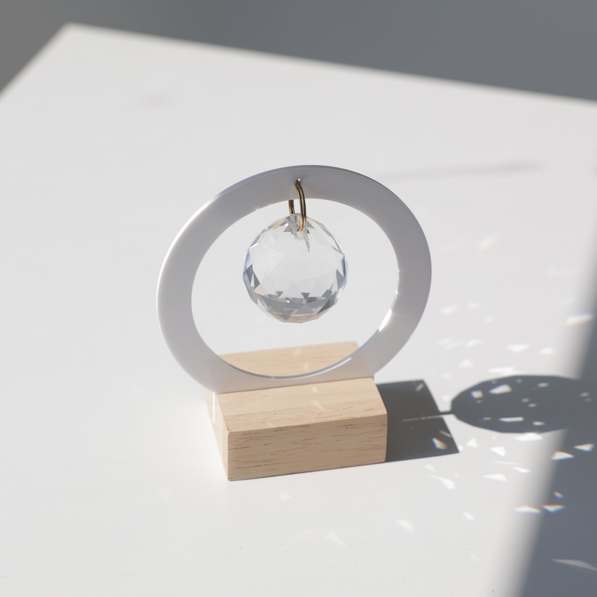 Mini Suncatcher Charlie avec une base en bois, un cristal transparent et une structure en acrylique