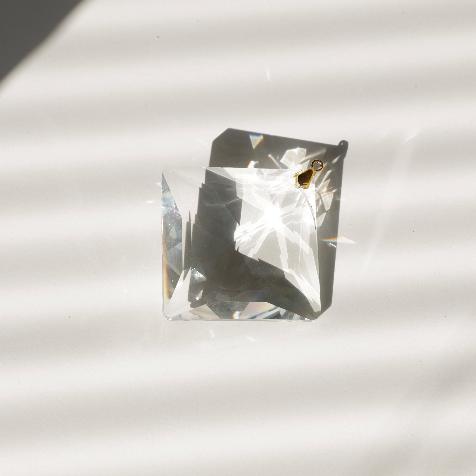 Gros plan sur le cristal ZENITH montrant ses prismes qui captent la lumière et projettent de magnifiques arcs-en-ciel.