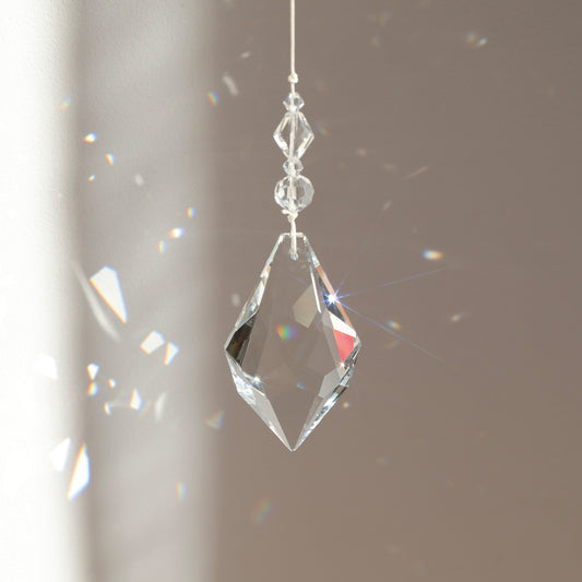 Suncatcher Etincelle de la marque Rayonne, placé au soleil et reflétant des reflets lumineux dans la pièce