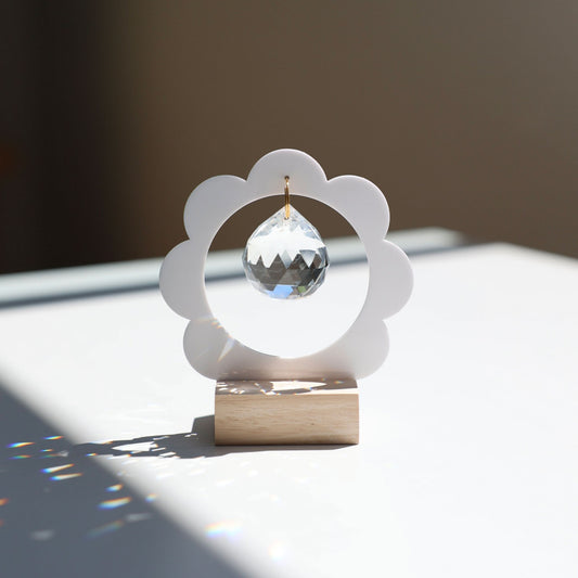 Objet décoratif Suncatcher posé sur une table, projetant des arcs-en-ciel dans un intérieur lumineux - Attrape-soleil Rayonne