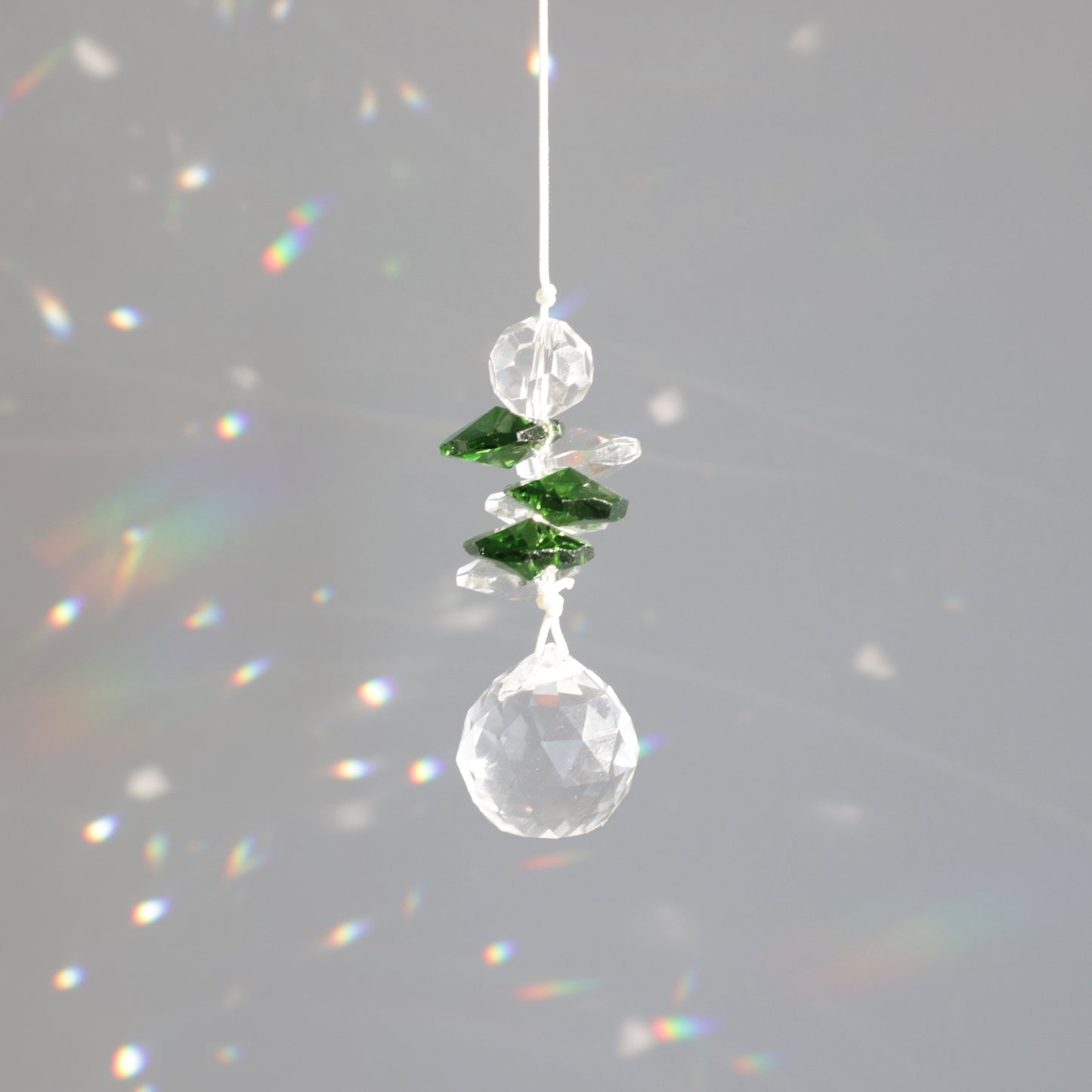 Petit Suncatcher symbole de chance, créant des reflets arcs-en-ciel dans la décoration