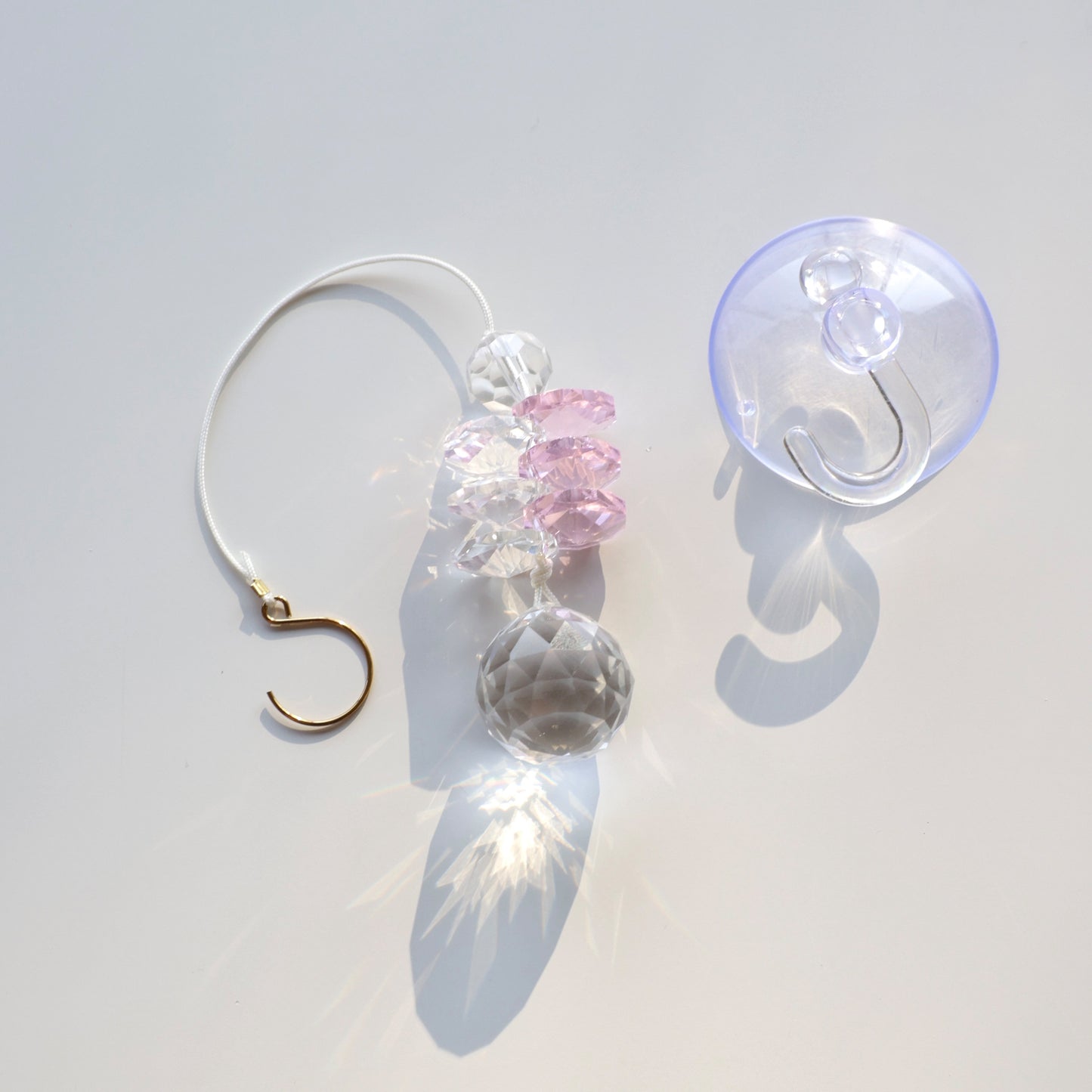 Présentation à plat du Suncatcher Mini Pink Aura, fourni avec une ventouse crochet