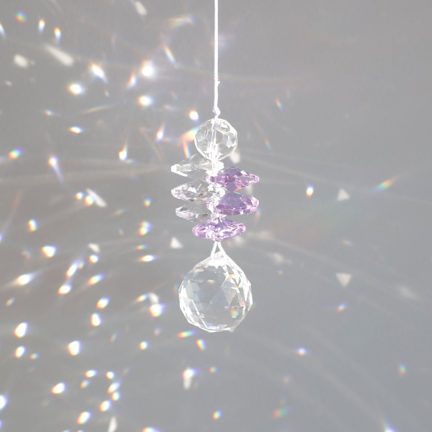 suncatcher en cristal transaprent et violet, diffusant des reflets arcs-en-ciel