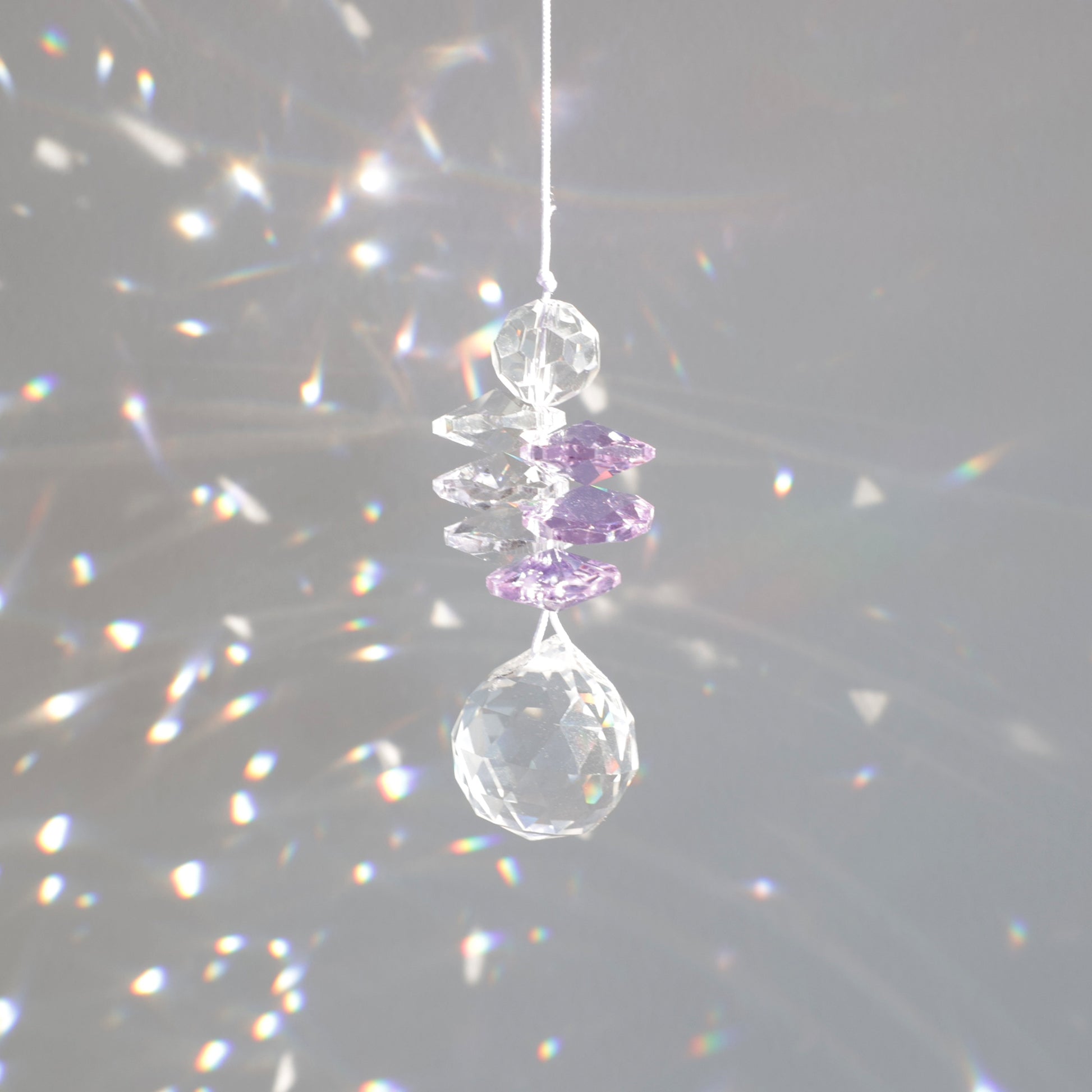 suncatcher en cristal transaprent et violet, diffusant des reflets arcs-en-ciel