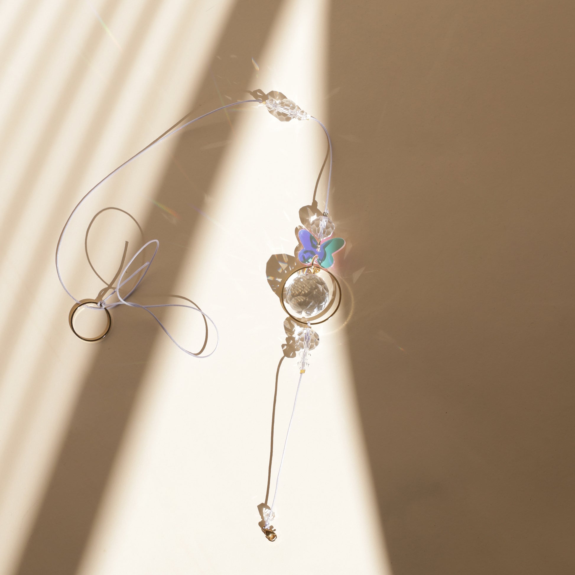 Rallonge LUEUR pour Suncatcher avec charm papillon, prête à être clipée sur un Suncatcher et diffuser des reflets arc-en-ciel.
