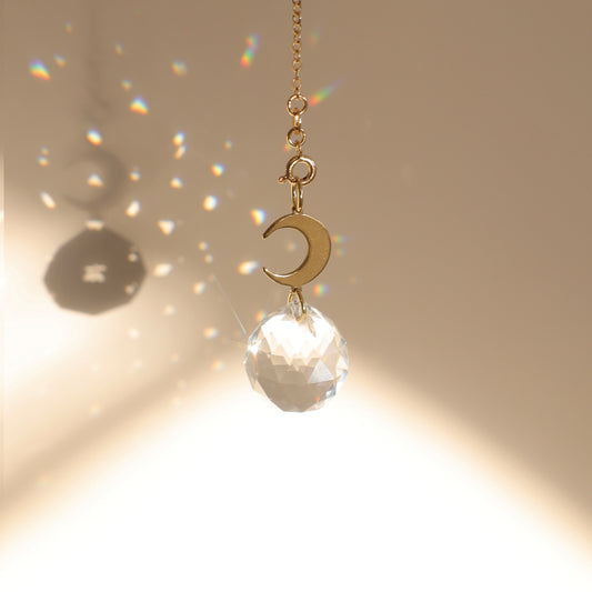 Attrape-soleil avec boule de cristal qui diffuse des reflets arcs-en-ciel dans la pièce