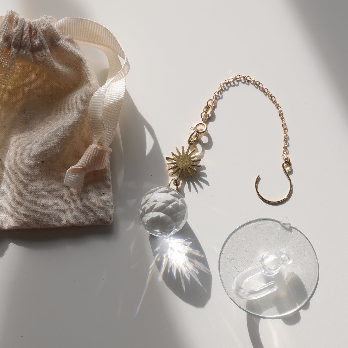 Suncatcher Baby Sun de Rayonne, vendu avec son pochon en coton et une ventouse pour une installation facile