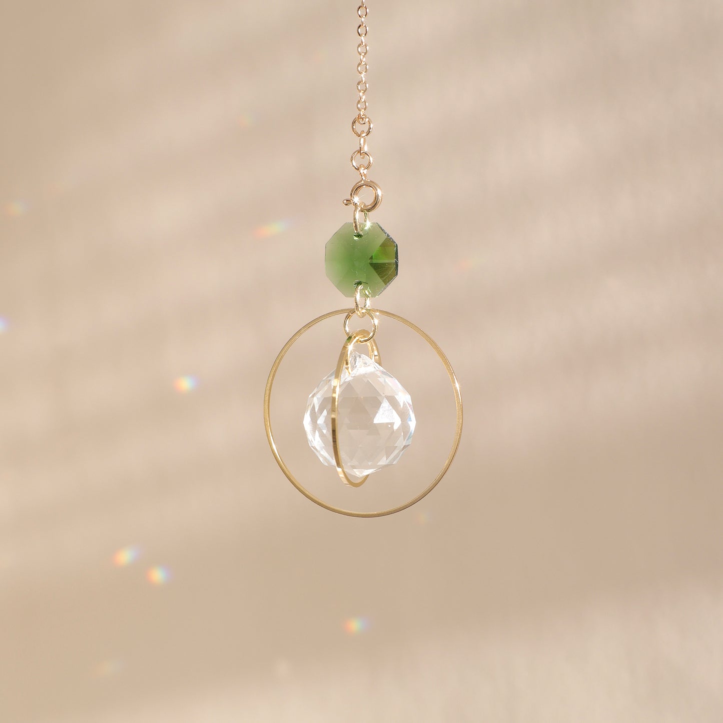 Suncatcher de la marque Rayonne composé avec un cristal vert, symbole de chance