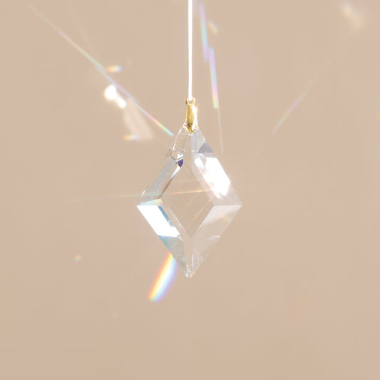 Suncatcher avec cristal transparent qui projette des reflets arcs-en-ciel dans la pièce