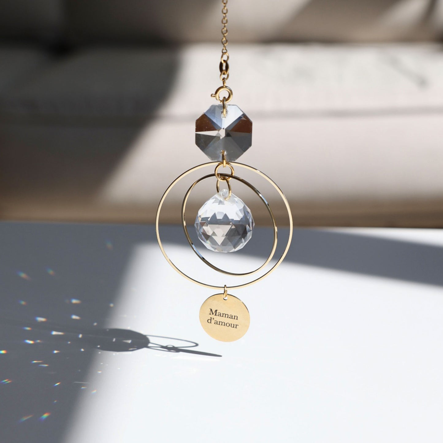 Jeux de lumière arc-en-ciel projetés par le Suncatcher MAMAN dans une pièce baignée de soleil - Rayonne