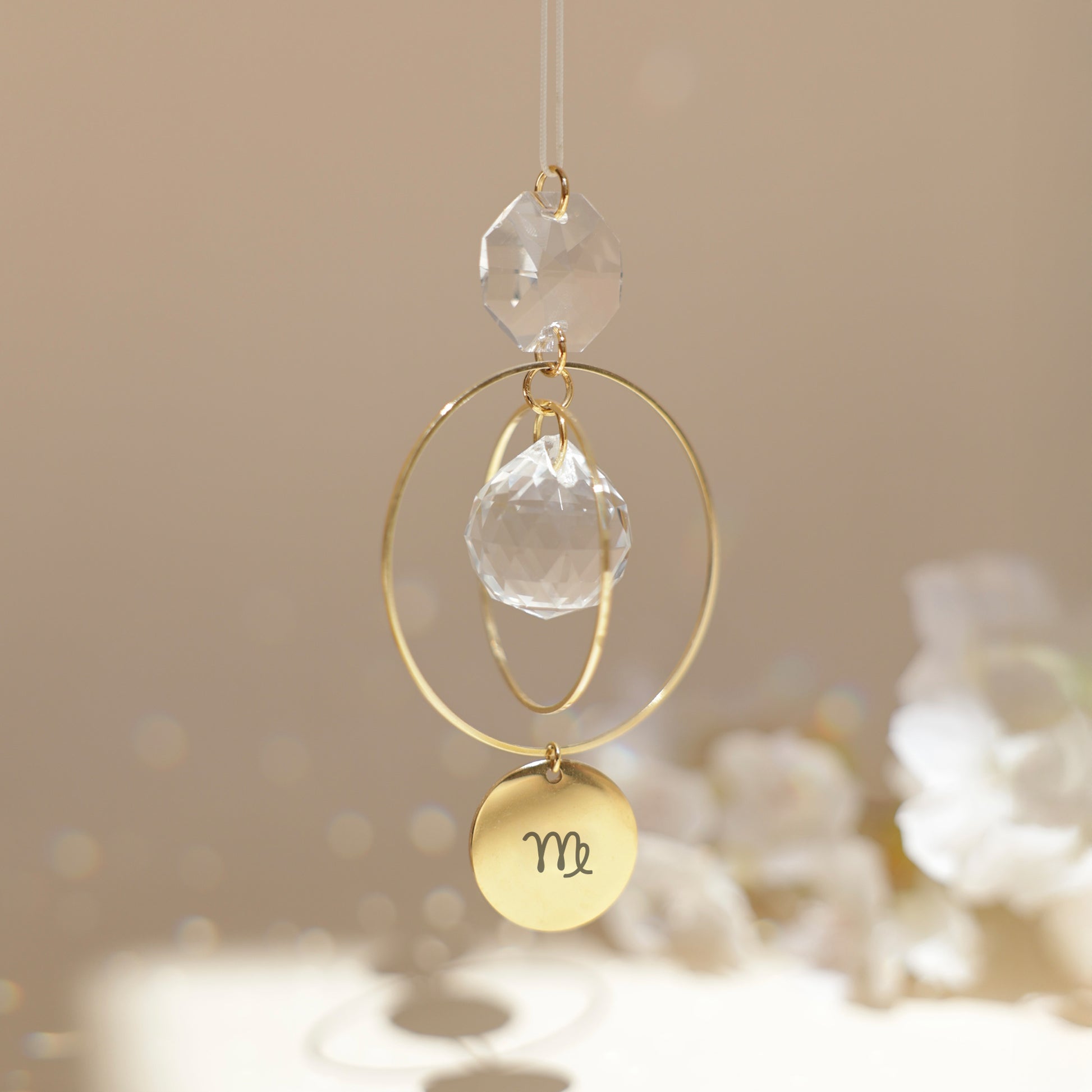 Suncatcher personnalisé avec médaillon gravé du signe astrologique, reflétant des arcs-en-ciel au soleil. Fabriqué en France.