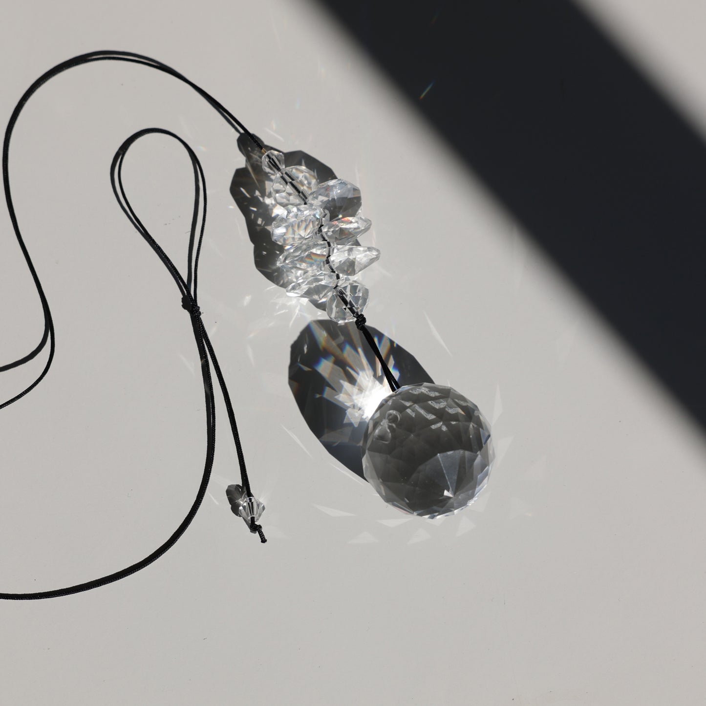 Suncatcher PEARL transparent posé sur une table à la lumière du soleil