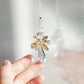 Suncatcher ANGE accroché contre une fenêtre, diffusant arcs-en-ciel et énergies positives pour illuminer l’intérieur.