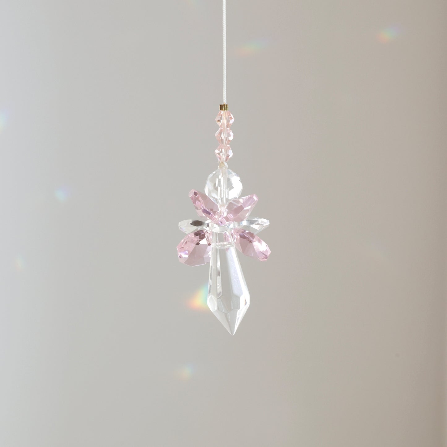 Suncatcher ANGE de la marque Rayonne® suspendu avec son cordon ajustable de 30 cm, diffusant de bonnes énergies.