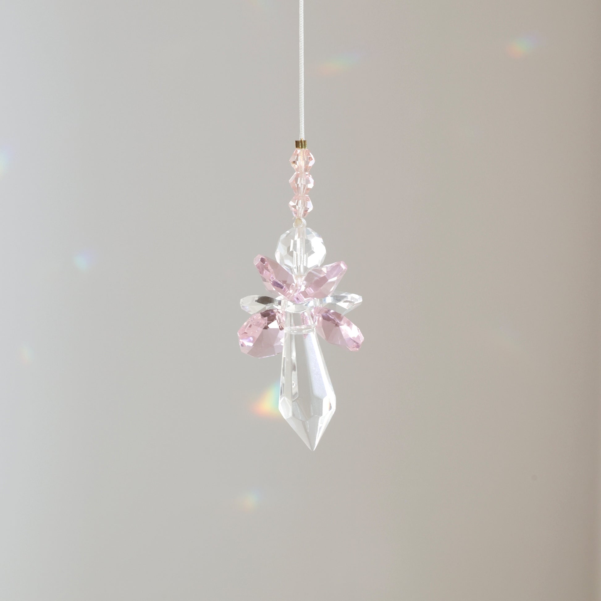 Suncatcher ANGE de la marque Rayonne® suspendu avec son cordon ajustable de 30 cm, diffusant de bonnes énergies.