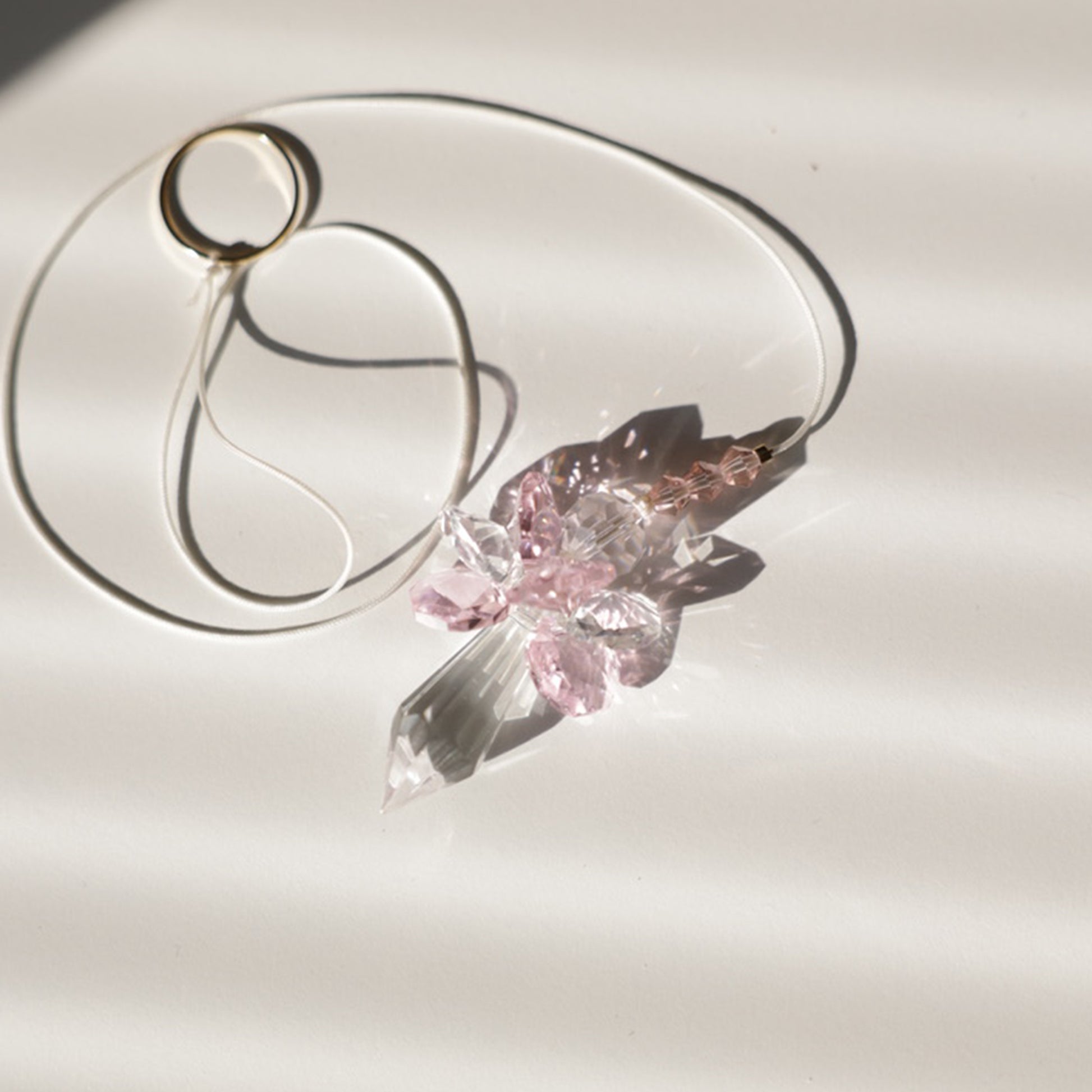 Suncatcher ANGE en cristal de couleur rose, fabriqué avec un cordon de taille ajustable. Symbole de protection et cadeau de naissance original.