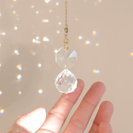 Gros plan sur le Suncatcher du mini Suncatcher CARAT captant la lumière du soleil et projetant des couleurs vibrantes dans la pièce