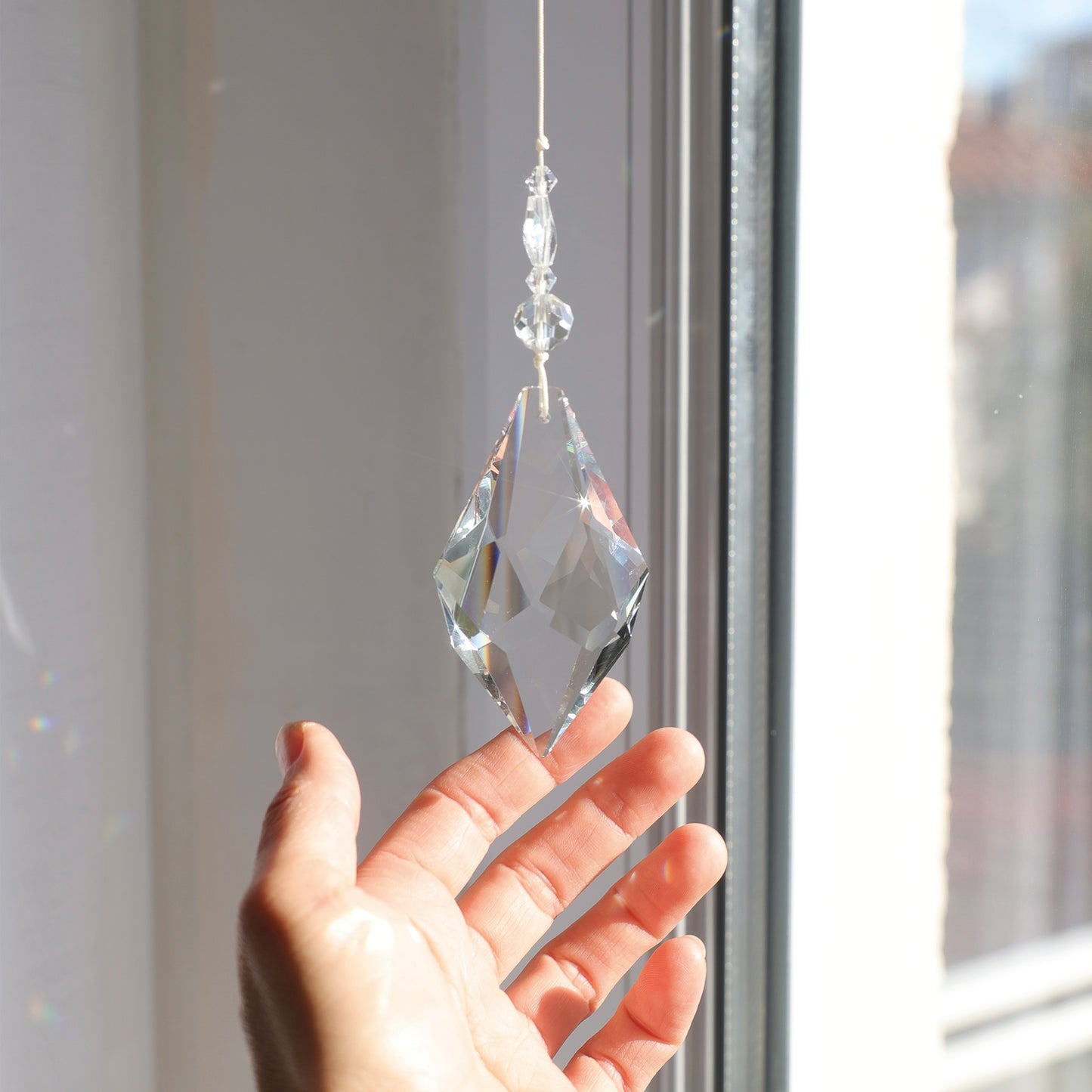 Suncatcher Etincelle accroché près d'une fenêtre ensoleillée