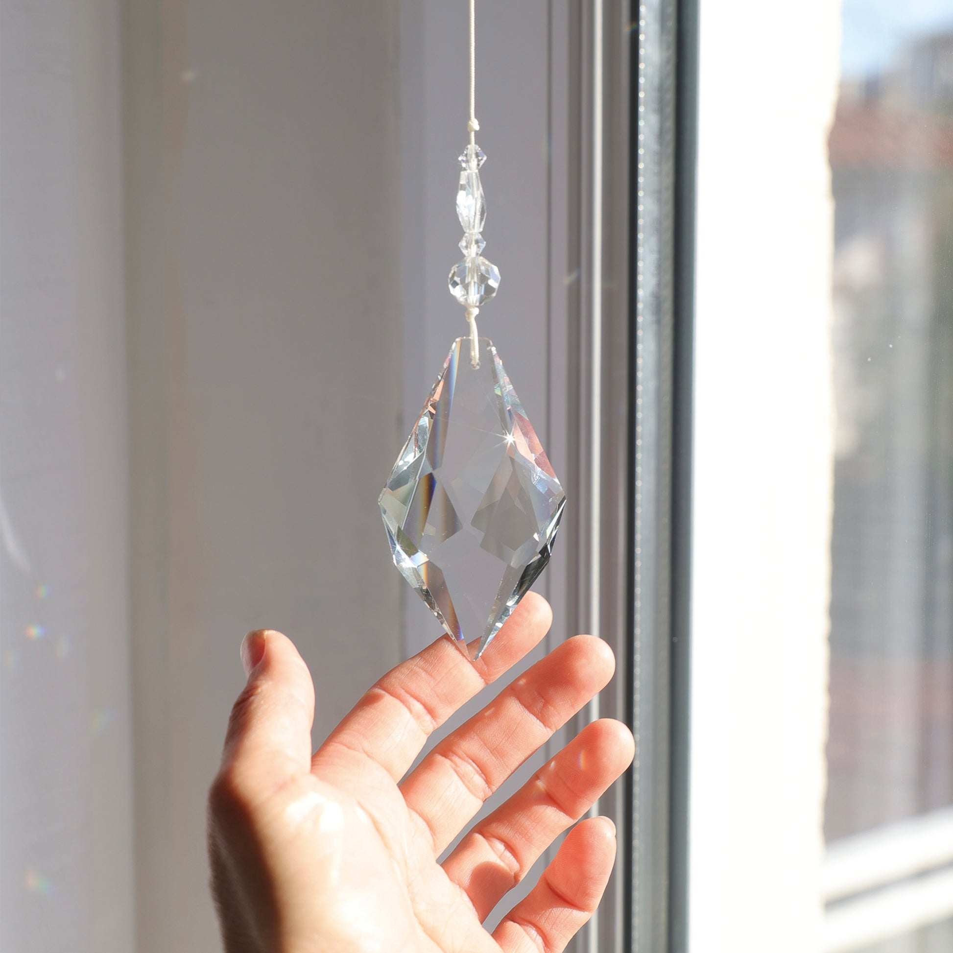 Suncatcher Etincelle accroché près d'une fenêtre ensoleillée