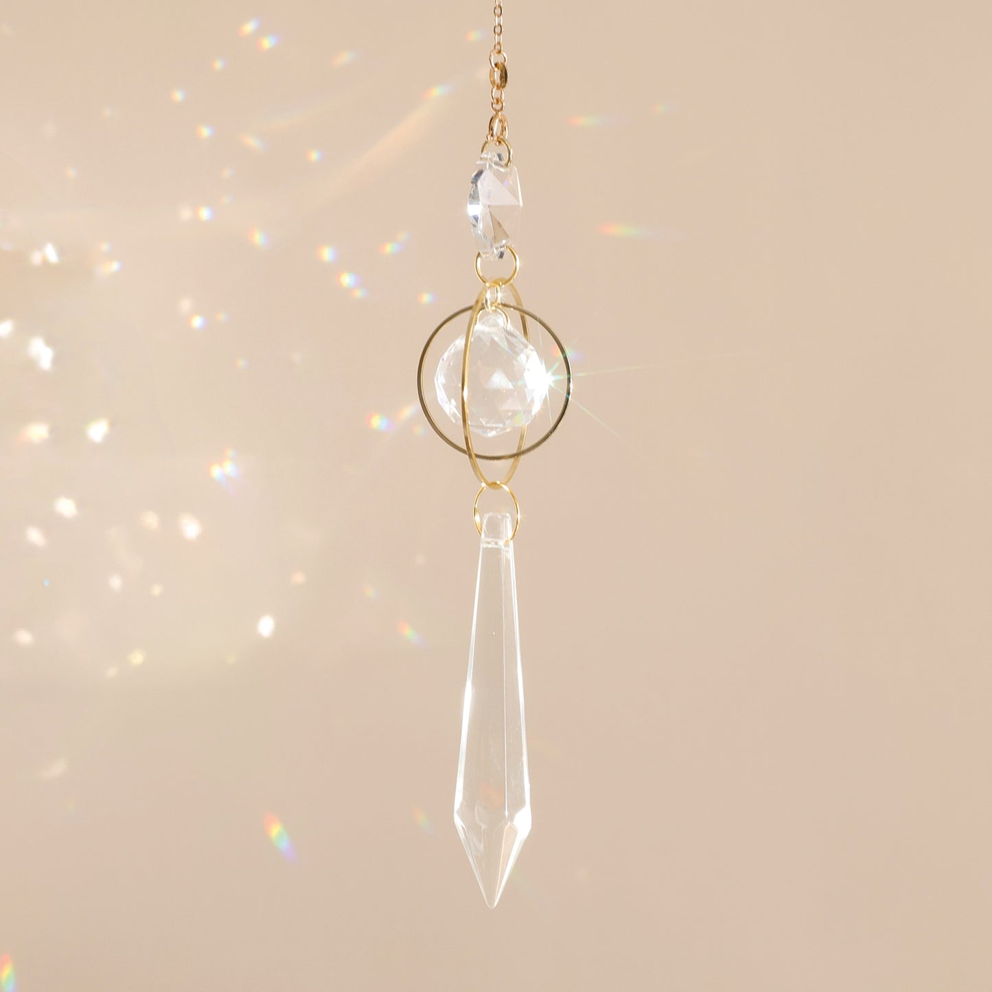 Suncatcher GOOD KARMA suspendu près d’une fenêtre, diffusant des reflets arc-en-ciel et apportant sérénité et harmonie à l’espace.