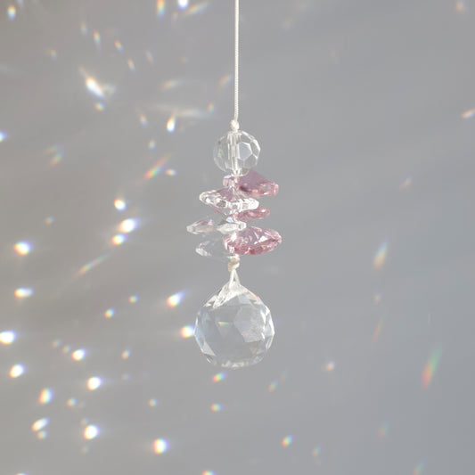 Décoration magique du suncatcher Pink Aura captant le soleil et diffusant des éclats multicolores pour une ambiance douce.