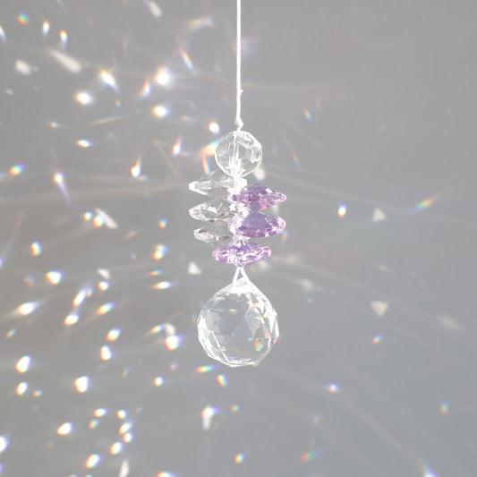 suncatcher en cristal transaprent et violet, diffusant des reflets arcs-en-ciel