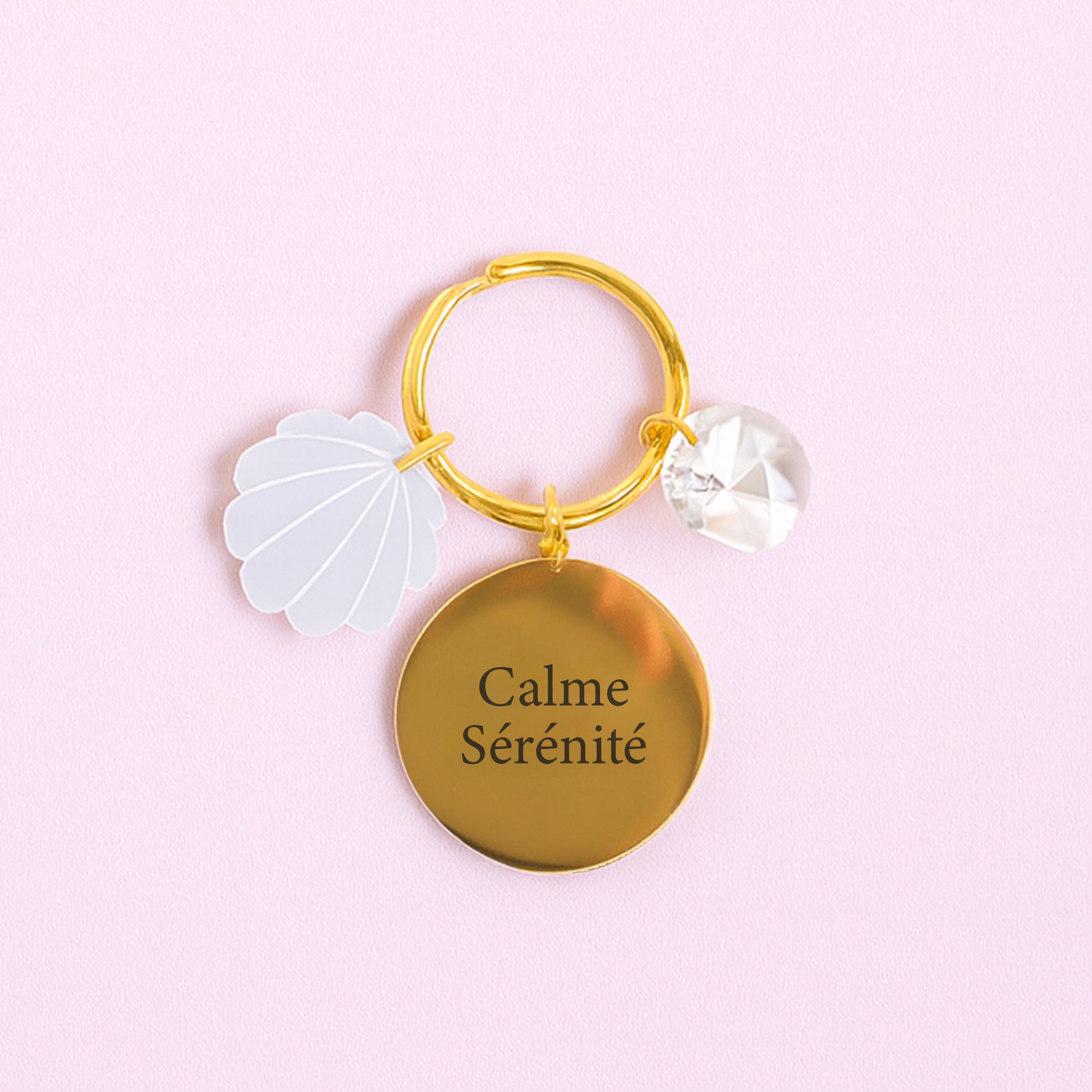 Porte-clés SÉRÉNITÉ Rayonne® avec médaillon gravé, charm coquillage en acrylique et cristal transparent, symbole de paix et sérénité