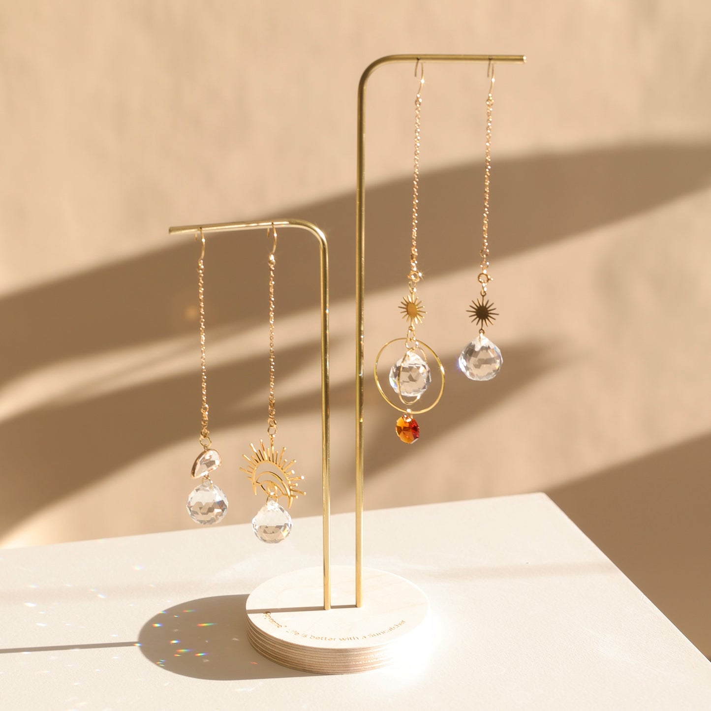 Présentoir Suncatchers avec 2 tiges pour 4 Suncatchers, base en bois gravée Rayonne®, mis en scène au soleil.