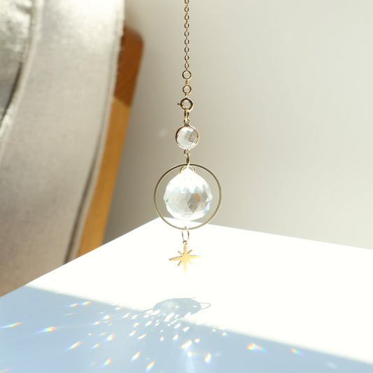 Zoom sur le cristal de l'attrape-soleil ASTRA, captant les rayons du soleil pour créer des jeux de lumière colorés.