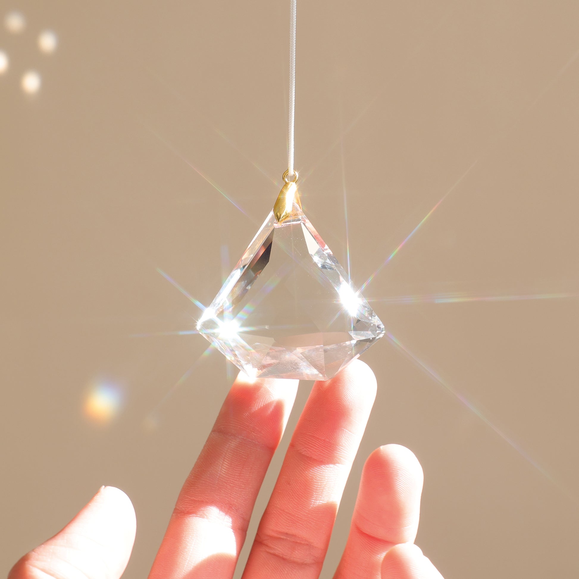 Attrape-soleil avec cristal transparent, qui reflète des prismes lumineux arcs-en-ciel dans la pièce