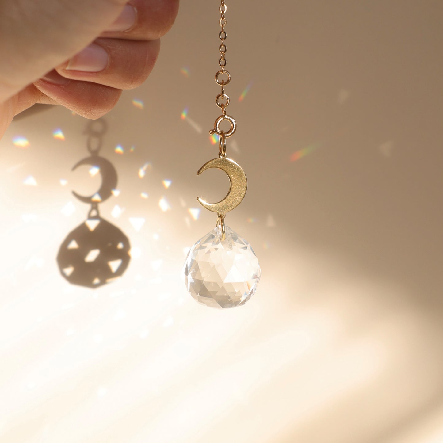 Suncatcher BABY MOON dans un intérieur lumineux, créant des reflets arcs-en-ciel