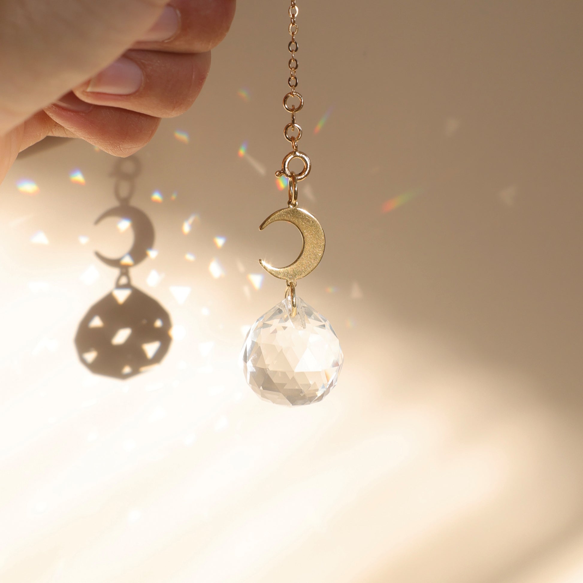 Suncatcher BABY MOON dans un intérieur lumineux, créant des reflets arcs-en-ciel