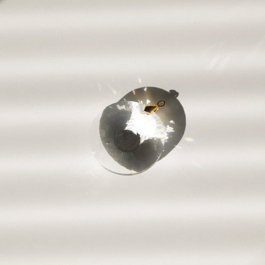 Gros plan sur le Sucnatcher CIRCLE montrant ses facettes captant la lumière et projetant des reflets colorés quand il est placé au soleil