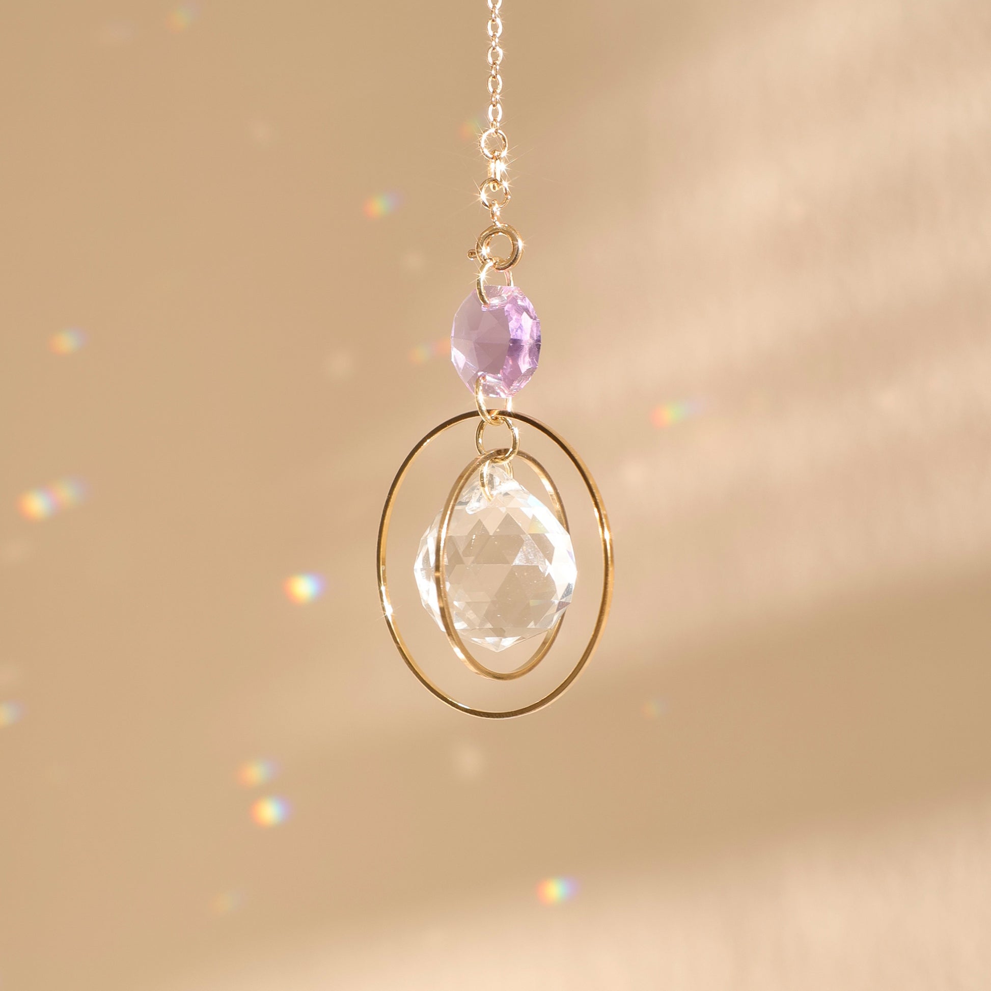 Suncatcher EVERLIGHT violet clair captant la lumière du soleil, projetant des reflets arc-en-ciel et favorisant la spiritualité.