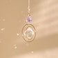 Suncatcher EVERLIGHT violet clair captant la lumière du soleil, projetant des reflets arc-en-ciel et favorisant la spiritualité.