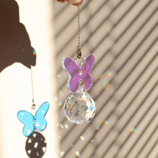 Attrape-soleil IRIS de la marque Rayonne® avec papillon holographique suspendu, reflétant la lumière en arcs-en-ciel.