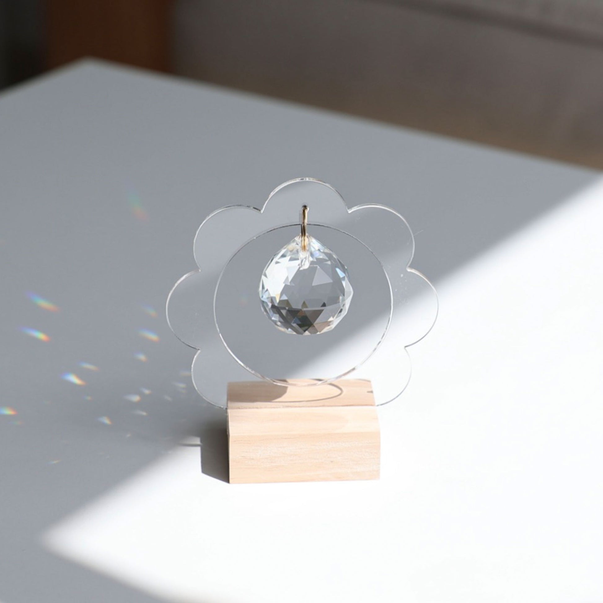 Reflets arc-en-ciel projetés sur un mur par le Suncatcher LILLIE exposé à la lumière directe du soleil.