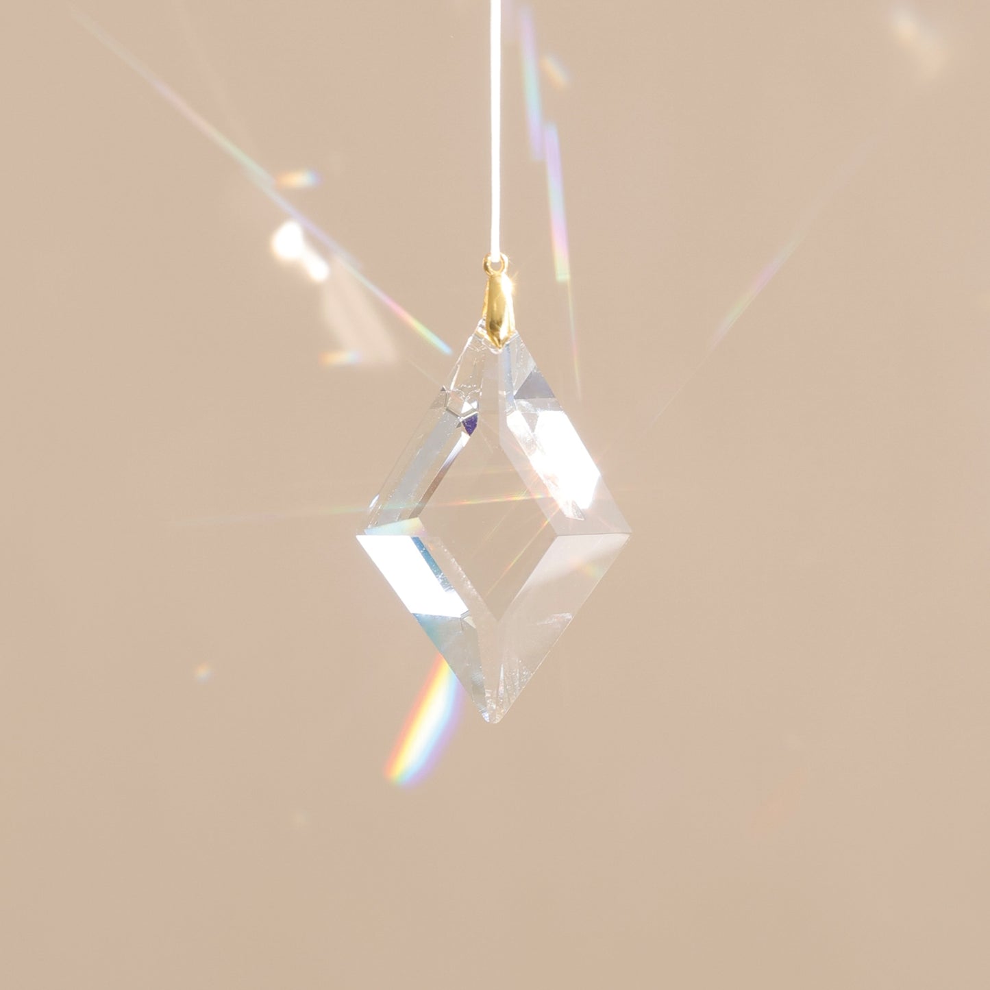 Suncatcher avec cristal transparent qui projette des reflets arcs-en-ciel dans la pièce