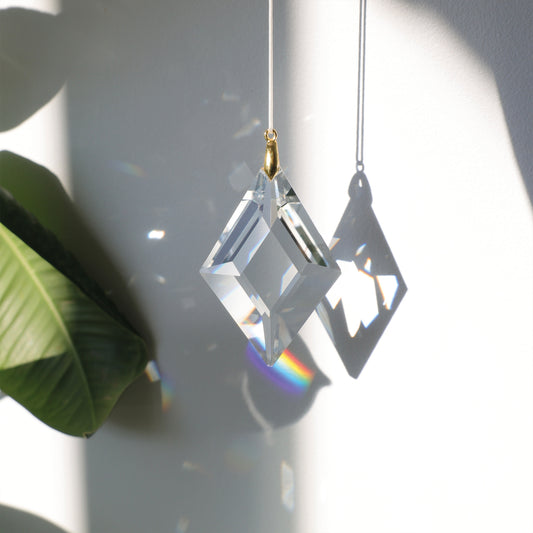 Suncatcher LUCKY CHARM en cristal, projetant des reflets arc-en-ciel dans une pièce ensoleillée pour une ambiance douce et harmonieuse.