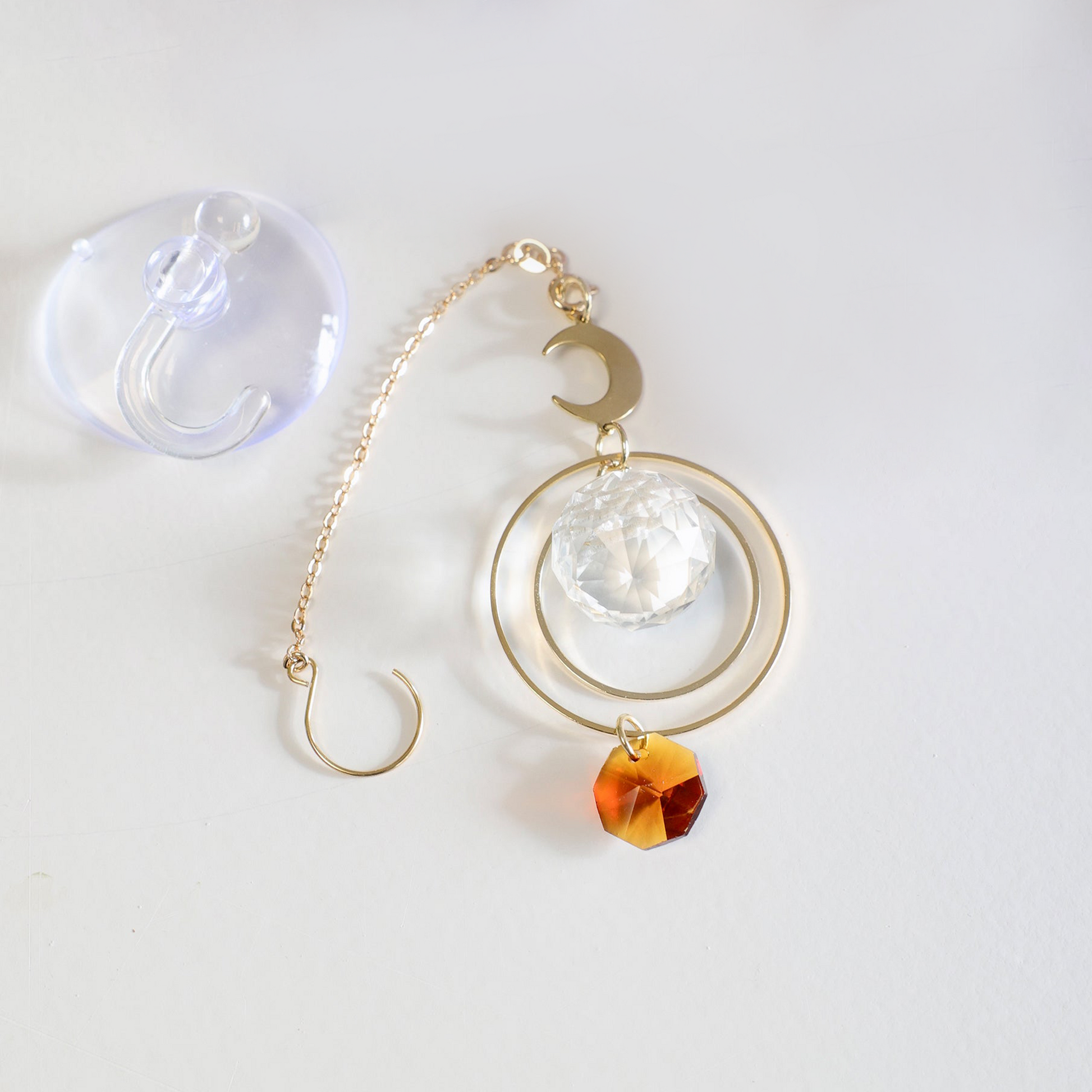 Suncatcher Magicmoon de la marque Rayonne, fourni avec une ventouse crochet et un pochon en satin