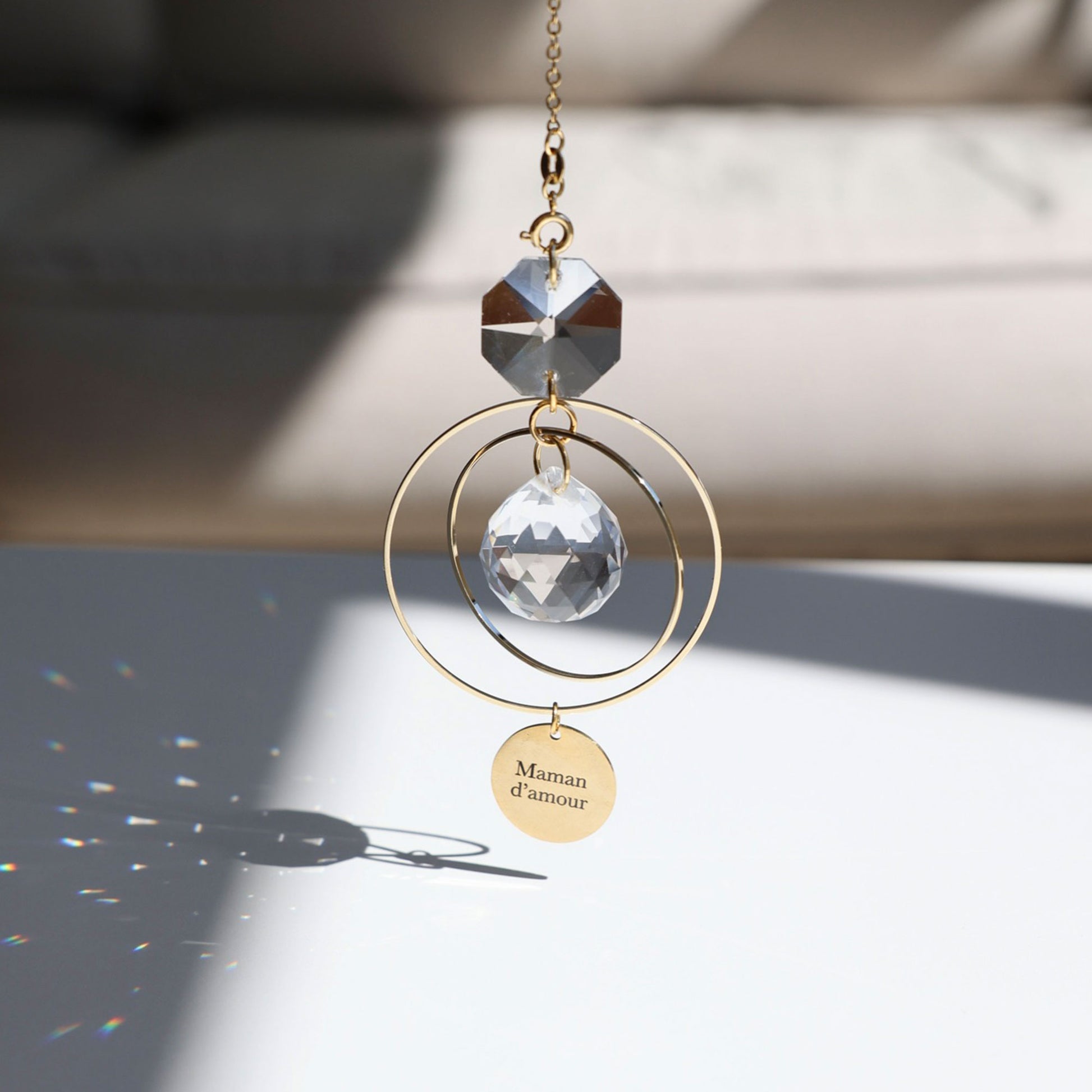 Jeux de lumière arc-en-ciel projetés par le Suncatcher MAMAN dans une pièce baignée de soleil - Rayonne
