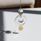 Suncatcher MAMAN en verre, suspendu près d'une fenêtre, prêt à capter les rayons du soleil.