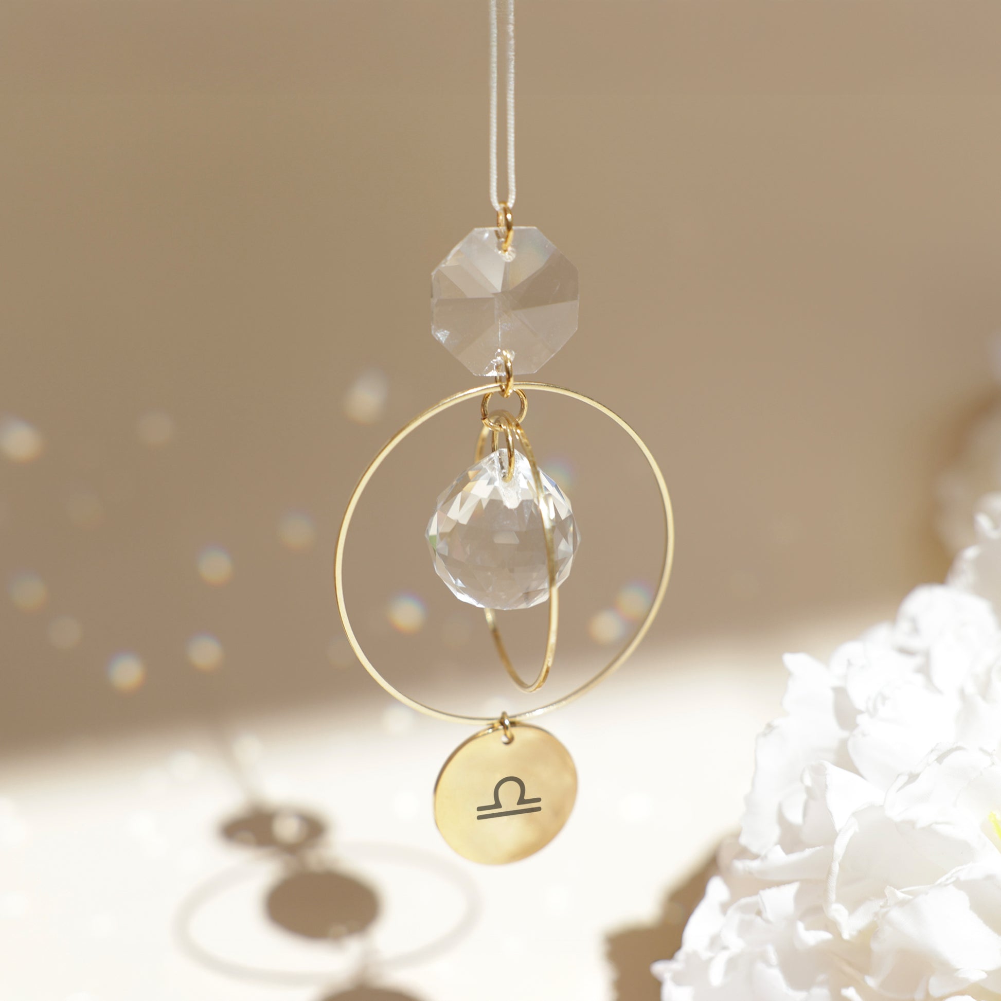 Suncatcher personnalisé avec signe astrologique, diffusant des reflets arc-en-ciel grâce aux cristaux.
