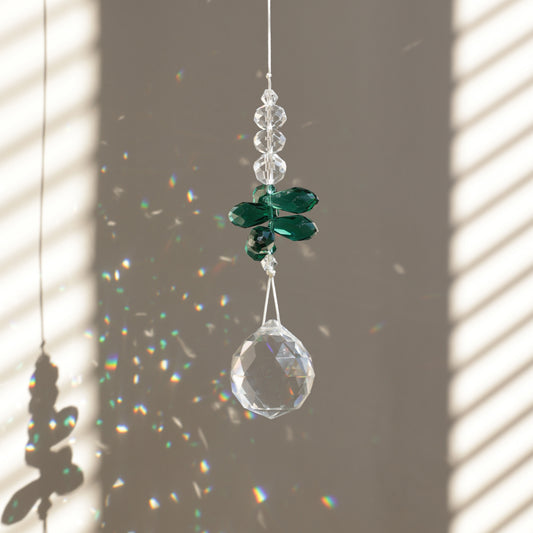 Suncatcher GLOW de la marque Rayonne® suspendu, diffusant des reflets scintillants dans la pièce