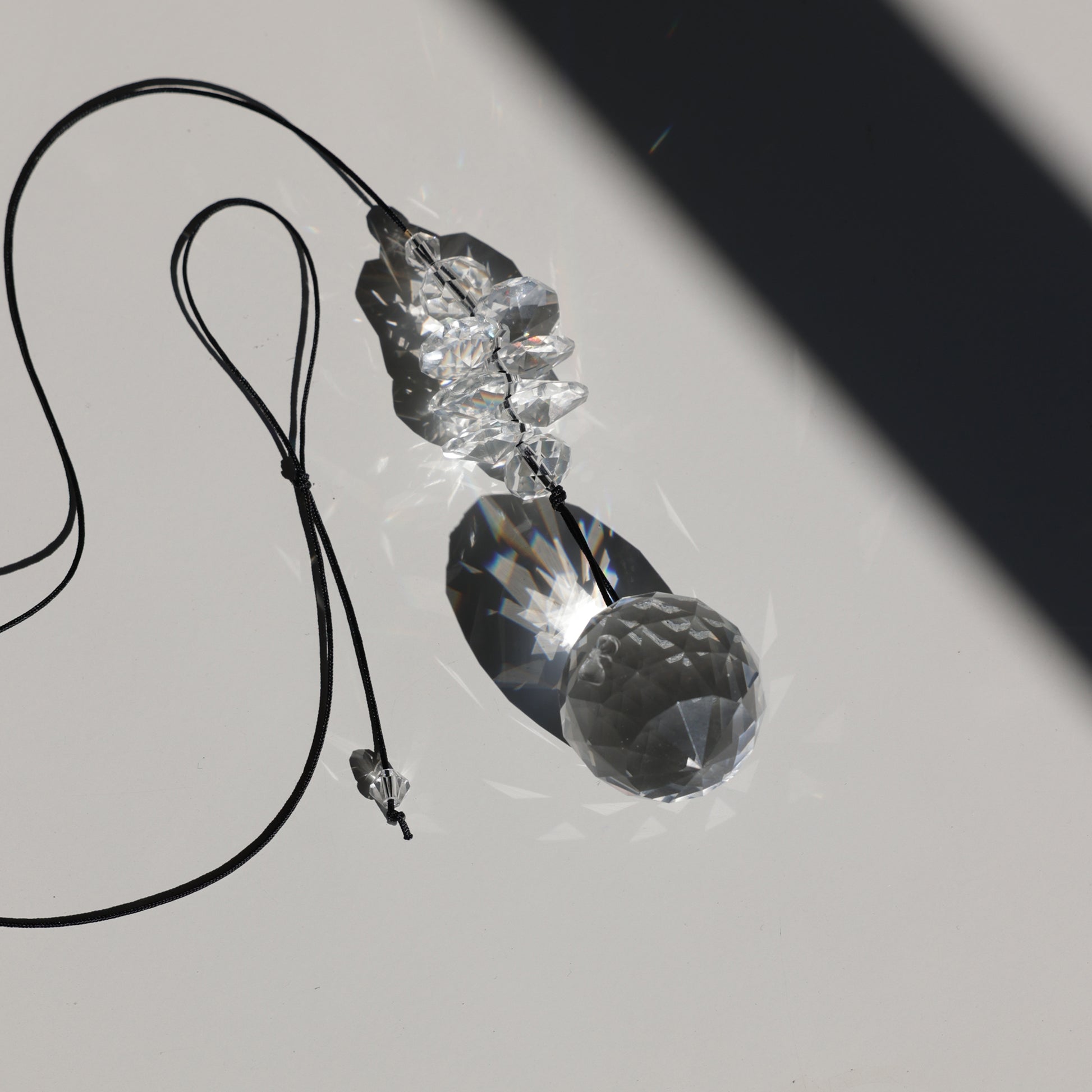 Suncatcher PEARL transparent posé sur une table à la lumière du soleil