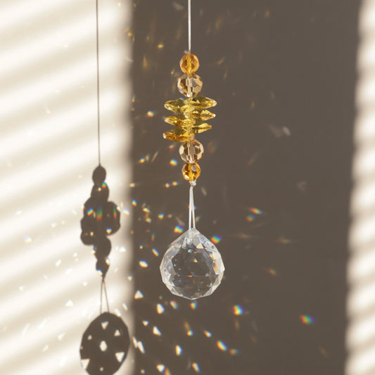 Suncatcher Solstice de la marque Rayonne® captant la lumière du soleil et reflétant des arcs-en-ciel