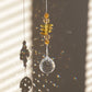 Suncatcher Solstice de la marque Rayonne® captant la lumière du soleil et reflétant des arcs-en-ciel
