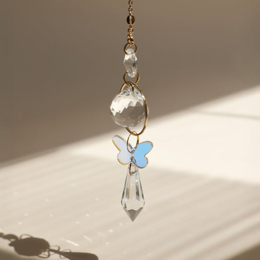 Attrape-lumière décoratif avec papillon, cristal suspendu créant une ambiance poétique grâce aux jeux de lumière du soleil.