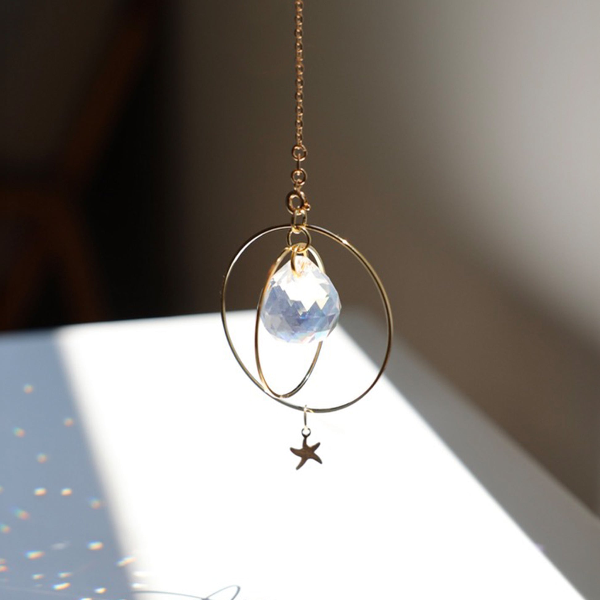 Décor lumineux avec le Suncatcher Sunset de Rayonne accroché dans une pièce baignée de lumière naturelle.