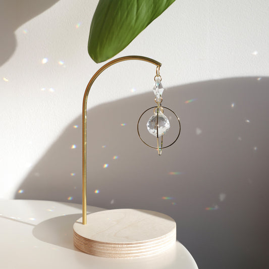 Reflets arc-en-ciel projetés par le suncatcher DAYDREAM posé sur une table